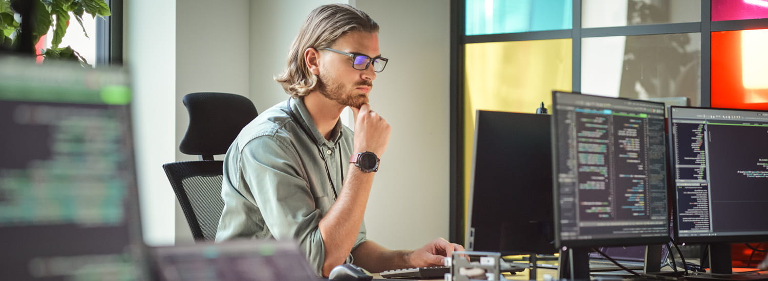 Male worker in thought while sitting at his desktop computer